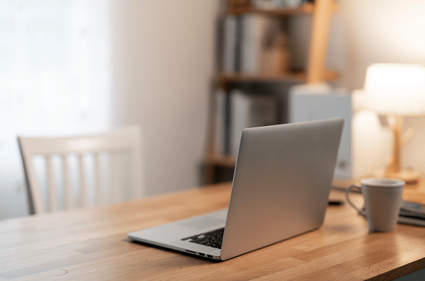 Ordinateur portable ouvert sur un bureau en bois clair.